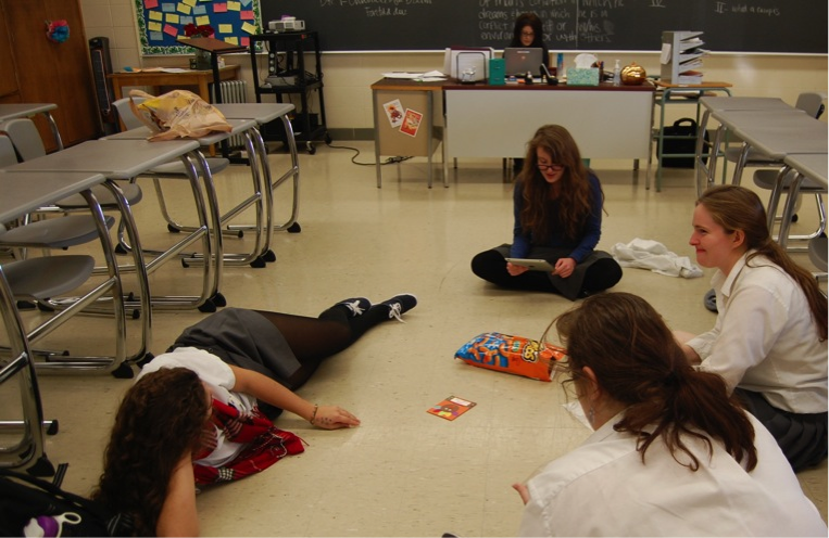 Seniors Meaghan Tilson, Amelia Fanelli, Christina Gee, and Alise Wenner convene for a Dead Poets Society Meeting, reading from a Thanksgiving childrens book of poems.