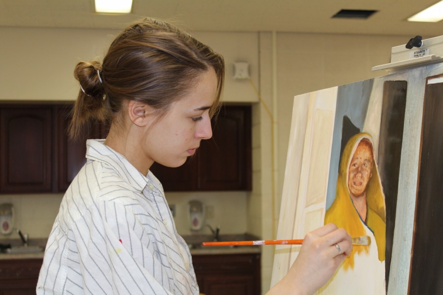 Junior Jaya Jankowski uses a dry brushing technique to block basic shapes into the first of many layers of her piece for Painting 2.  Photo Credit: Alicia Finnorn