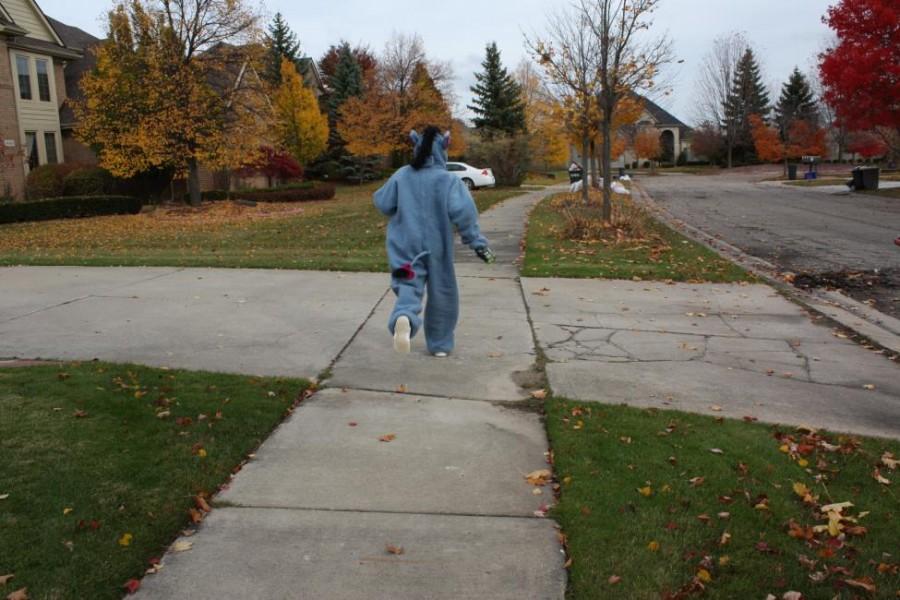 Freshman Emily Susitko is running to the next house in her trick or treating expedition, eager to see what treats await her. (Photo credit: Sydney Hughes)