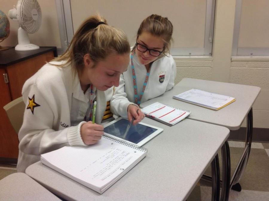 Erin Gormley performs a small act of kindness by helping Maddie Erdman prepare for her upcoming physics test. (Photo credit: Bridgette Conniff)
