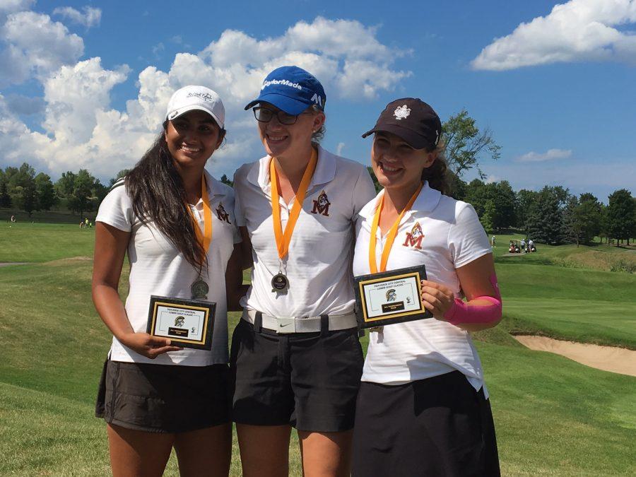Sophomore Mia Sooch (left) smiles with her victory medal and plaque for making the All-Tournament team for the Traverse City Central Lober Golf Classic, next to senior Marissa Lobbia (middle), and sophomore Sophie Vanderwheele (right). Photo Credit: Mia Sooch