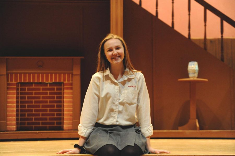 Cara Forfinski sits on the edge of the Mercy stage, awaiting rehearsal for her last Mercy musical, Mary Poppins.
