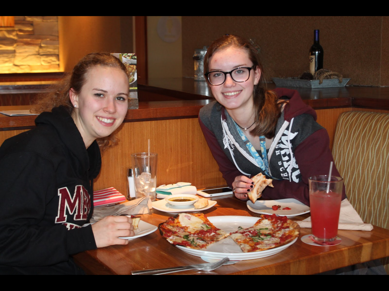 Seniors Kathryn Wolf (left) and Mackenzie Farrow split a margherita pizza, a CPK classic, while supporting Mercy through spirit wear and their bill.