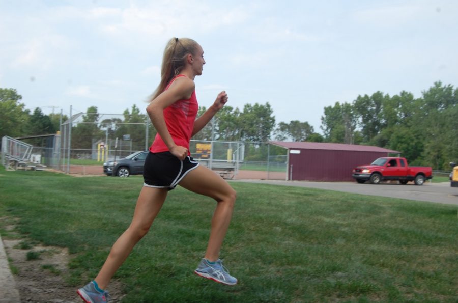 Mackenzie Sullivan strides at practice, working on improving her form and posture to help her in upcoming meets. Photo by Delilah Coe 

