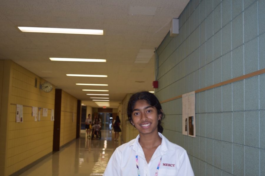 Senior Erica D’Souza smiles in the familiar hallways of the building where she has made her closest friends, as well as memories that will stay with her even through college. Photo by Megan Mallie
