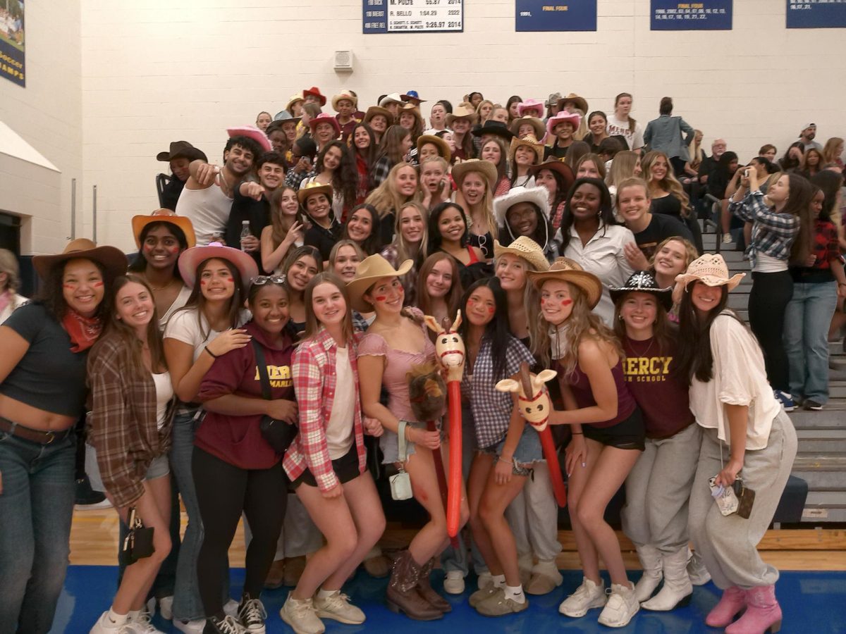 Mercy students pose in the student section at the game with their cowgirl attire.