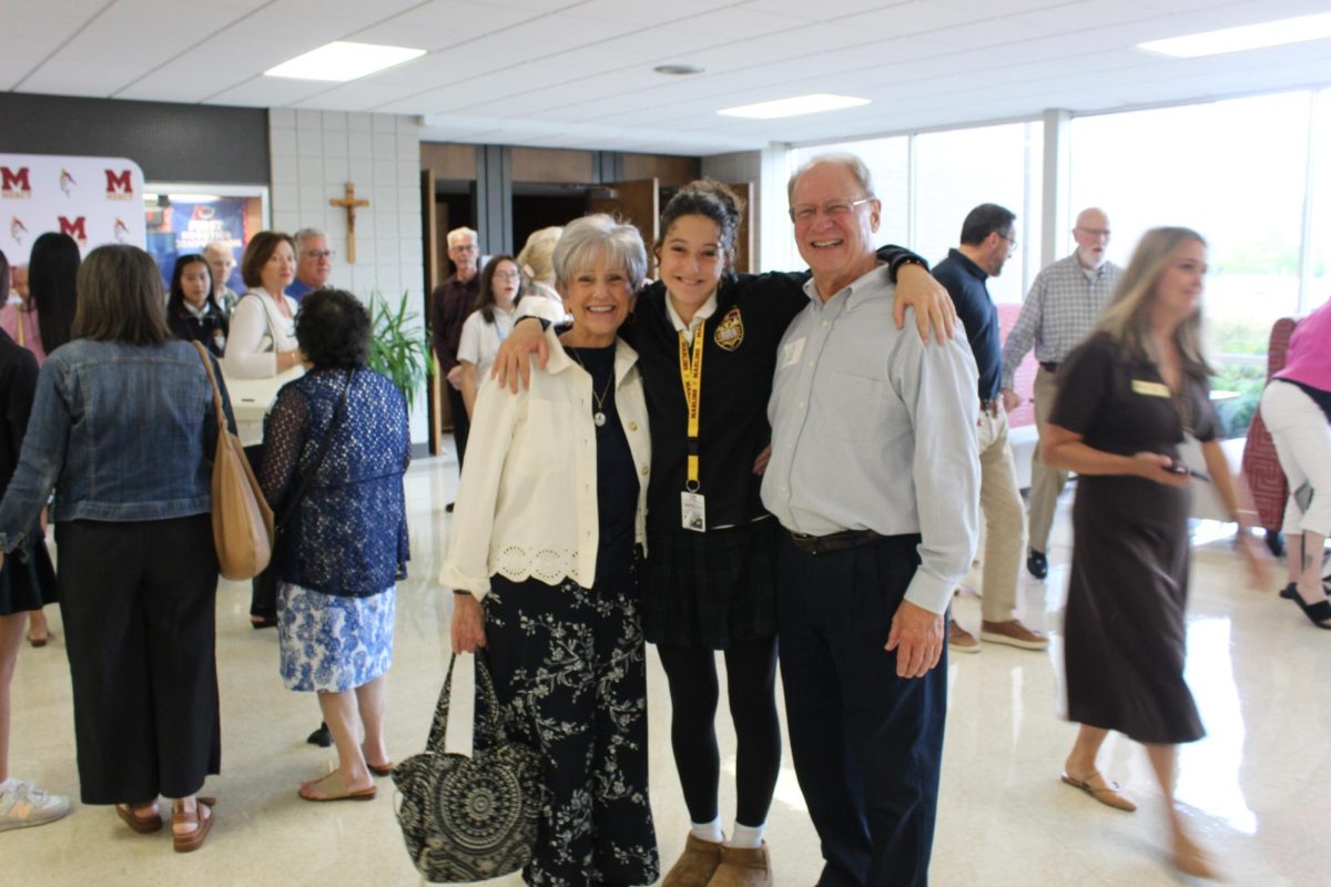 Freshman smiles with her grandparents before mass begins. 